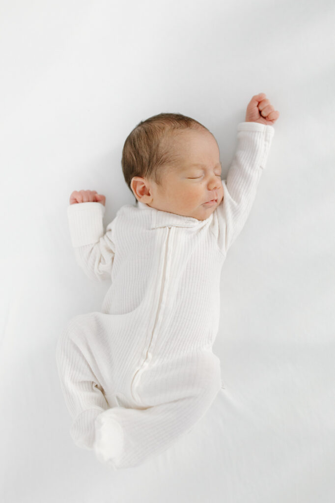 baby stretching during in-home newborn photos in indianapolis