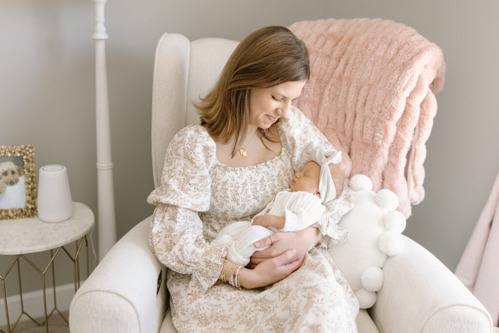 Mom holding her baby in her nursery during indianapolis newborn photos