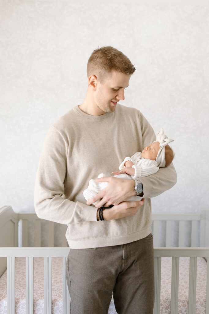 Dad smiling down towards his baby girl during indianapolis newborn photos