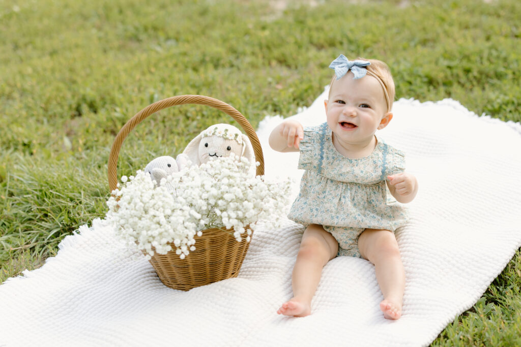 baby sitting on a blanket and smiling towards the camera during Indianapolis Milestone Photography session