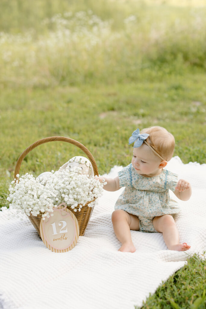 Little girl reaching for babies breath in basket during Indianapolis Milestone Photography session