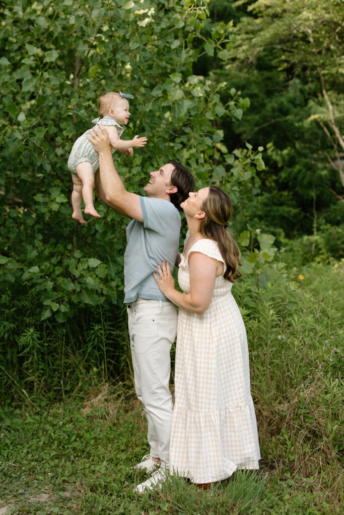 Mom and dad lifting little girl into the air during Indianapolis Milestone Photography session