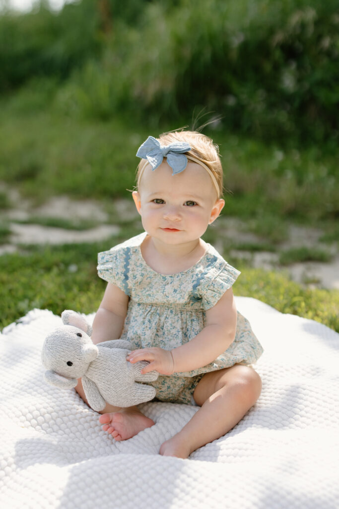 little girl smiling and holding onto stuffed elephant during Indianapolis Milestone Photography session