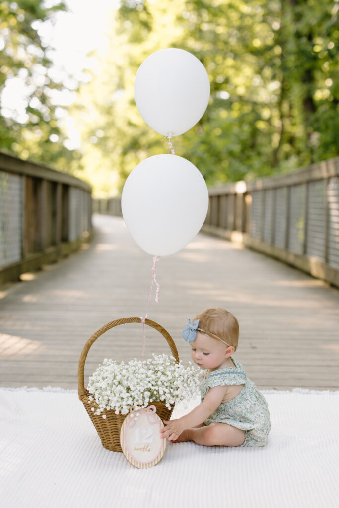 Baby reaching for 12 month sign during Indianapolis Milestone Photography session
