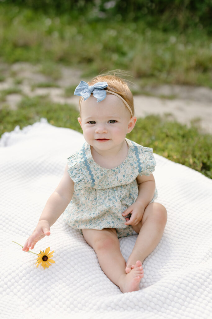 little girl reaching for flower during Indianapolis Milestone Photography session