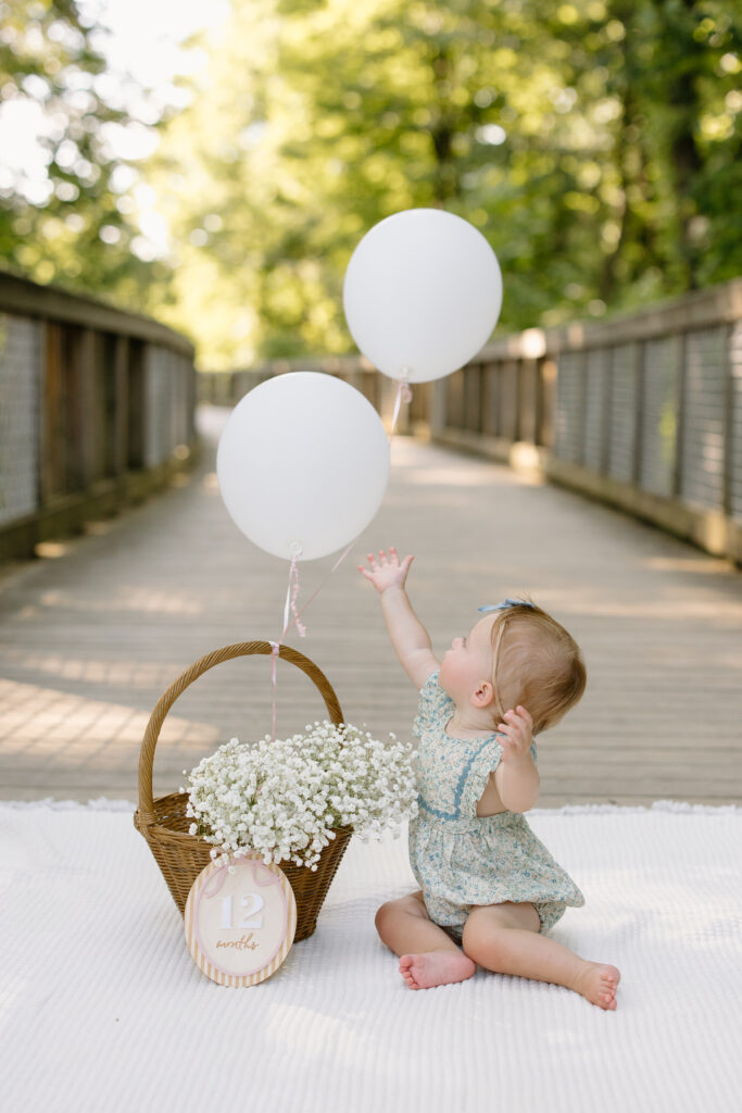 Baby side sitting and reaching for balloons during Indianapolis Milestone Photography session