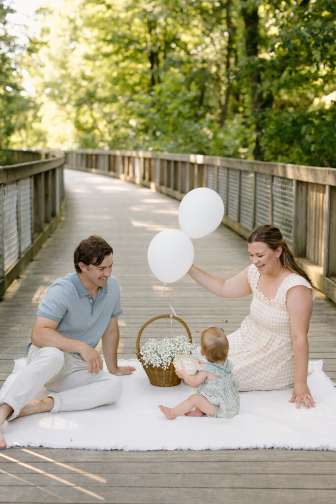 Parents playing with their little girl and balloons during Indianapolis Milestone Photography session