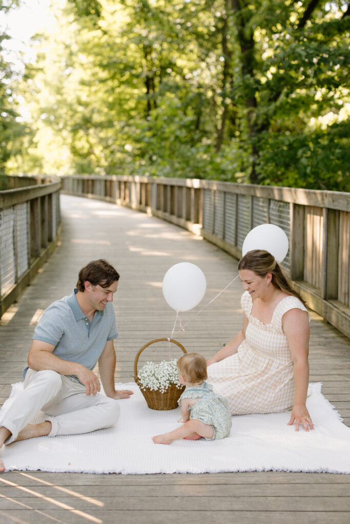 Parents sitting with baby on a blanket during Indianapolis Milestone Photography session