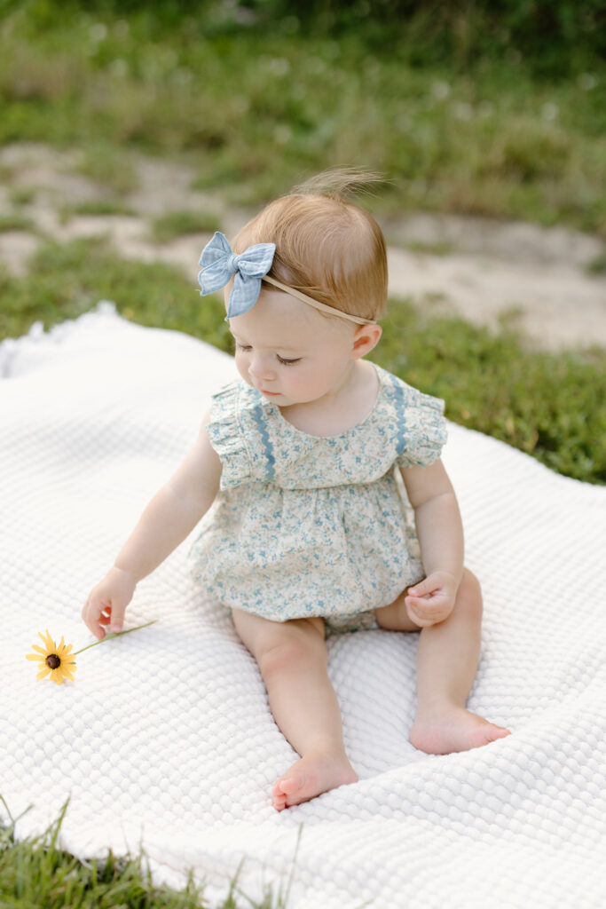 little girl grabbing flower during Indianapolis Milestone Photography session
