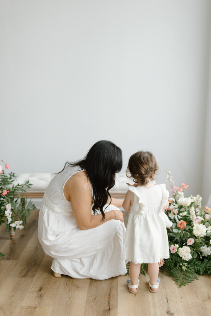 Mom and daughter playing with flowers during Mother's Day Mini Sessions at Aspiring Eden Studio in Indianapolis