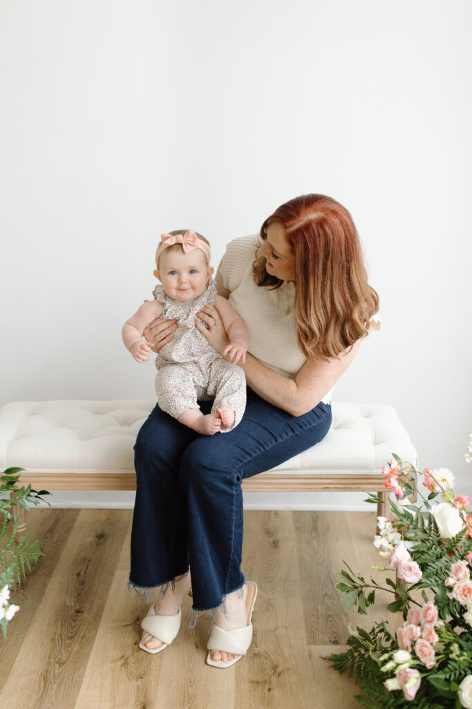 Mom holding daughter sitting on bench during Mother's Day Mini Sessions at Aspiring Eden Studio in Indianapolis