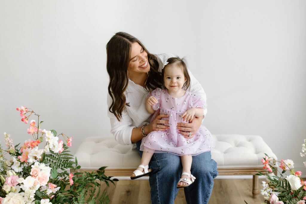Mom hugging daughter and smiling to camera during Mother's Day Mini Sessions at Aspiring Eden Studio in Indianapolis
