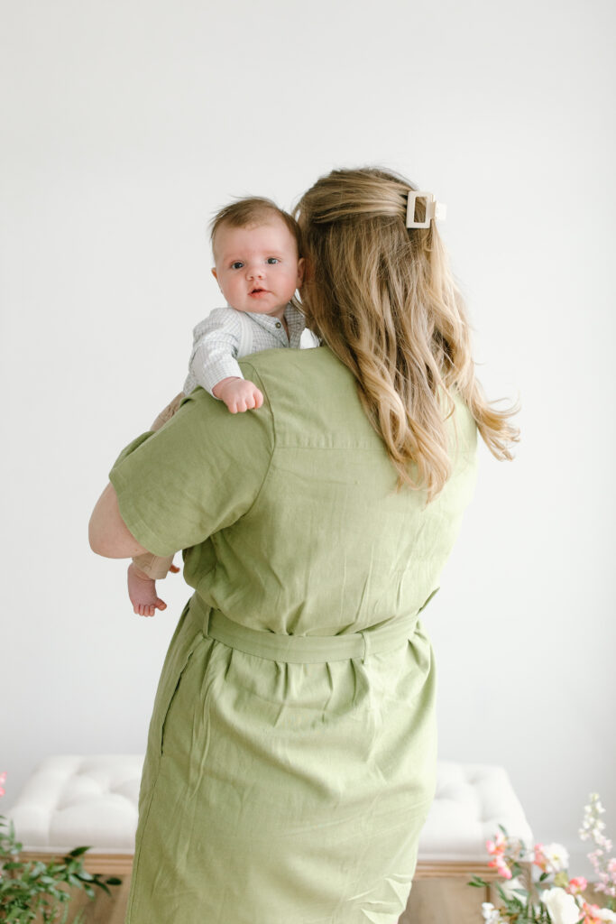 Mom carrying baby boy away during Mother's Day Mini Sessions at Aspiring Eden Studio in Indianapolis