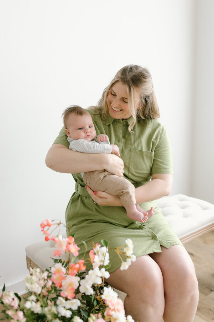 Mom holding son in front of flowers during Mother's Day Mini Sessions at Aspiring Eden Studio in Indianapolis