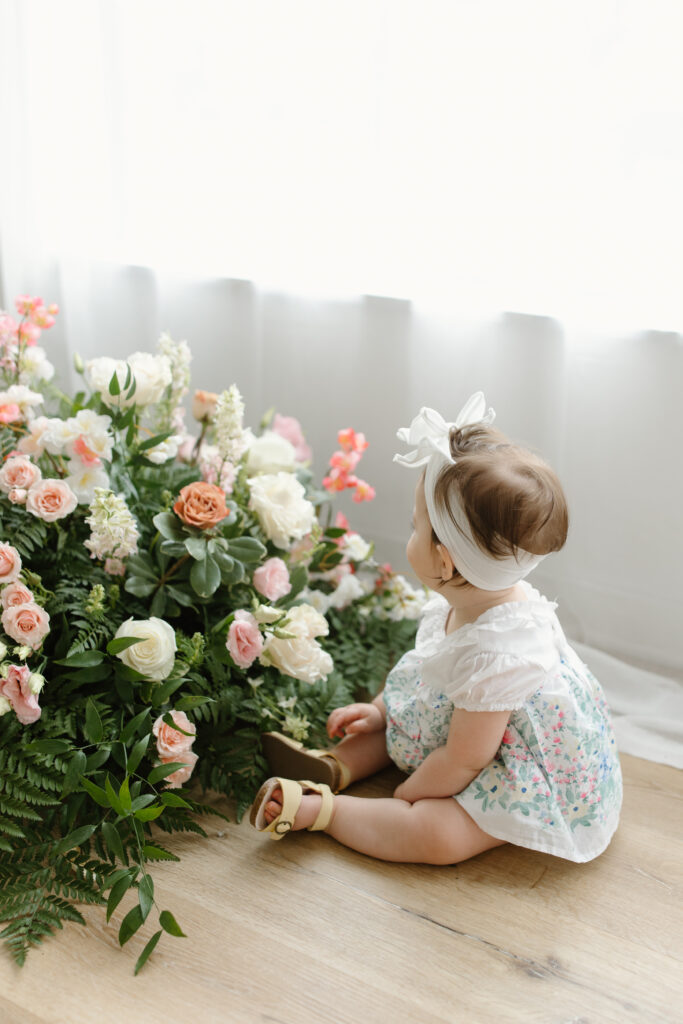 Little girl playing with flowers during Mother's Day Mini Sessions at Aspiring Eden Studio in Indianapolis