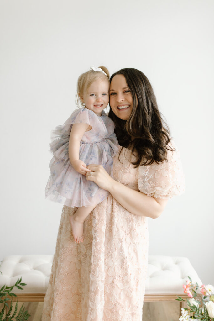 Mom and daughter smiling towards the camera during Mother's Day Mini Sessions at Aspiring Eden Studio in Indianapolis