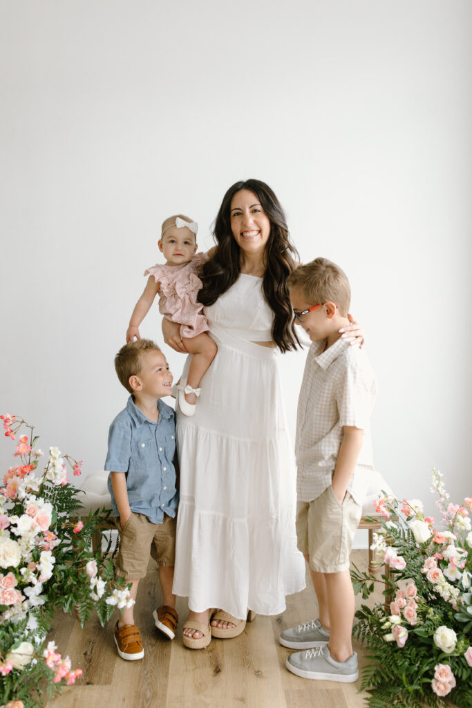 Mom holding her daughter and hugging her sons during Mother's Day Mini Sessions at Aspiring Eden Studio in Indianapolis