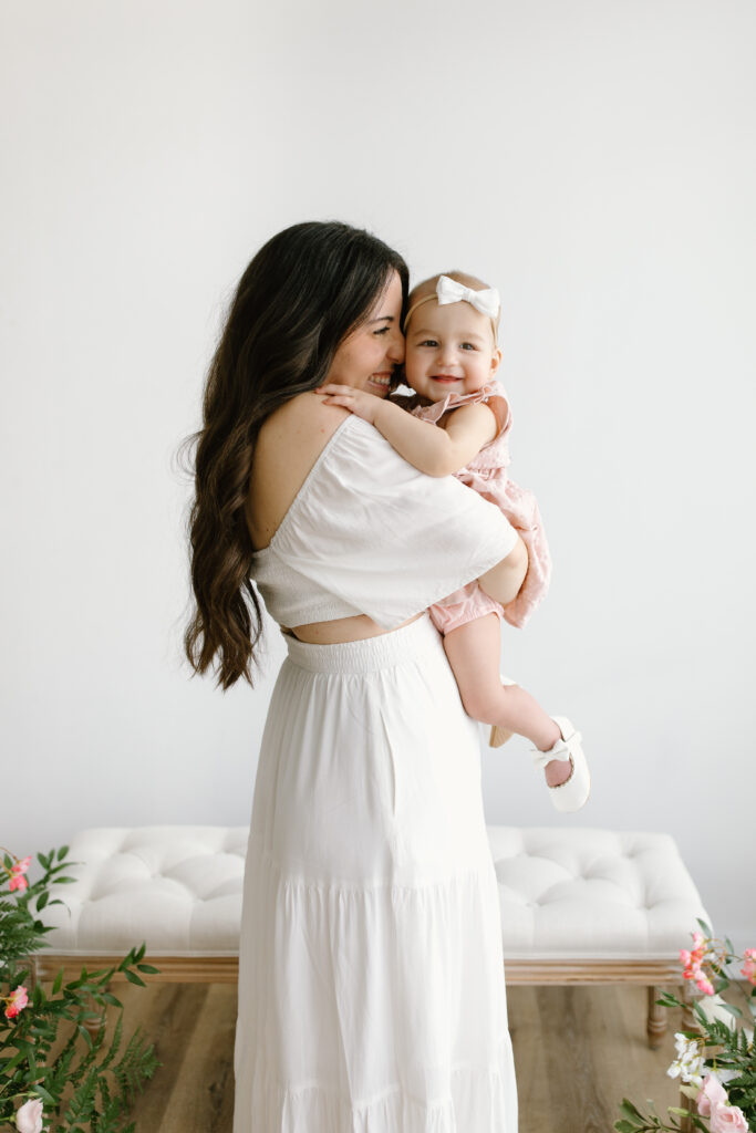 Mom snuggling into her baby girl during Mother's Day Mini Sessions at Aspiring Eden Studio in Indianapolis