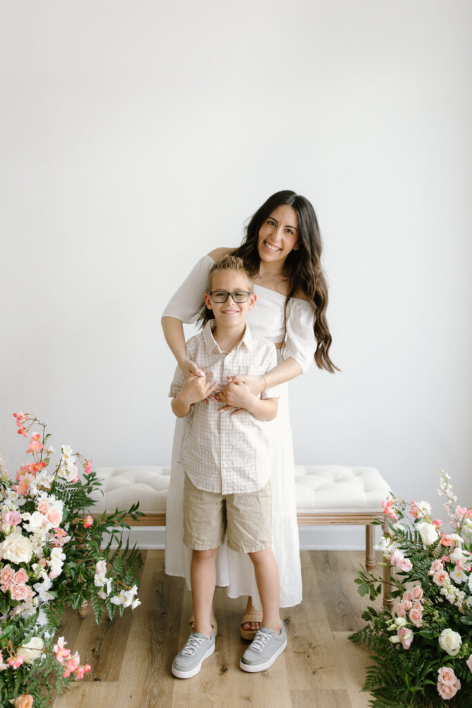 Mom hugging her son from behind during Mother's Day Mini Sessions at Aspiring Eden Studio in Indianapolis