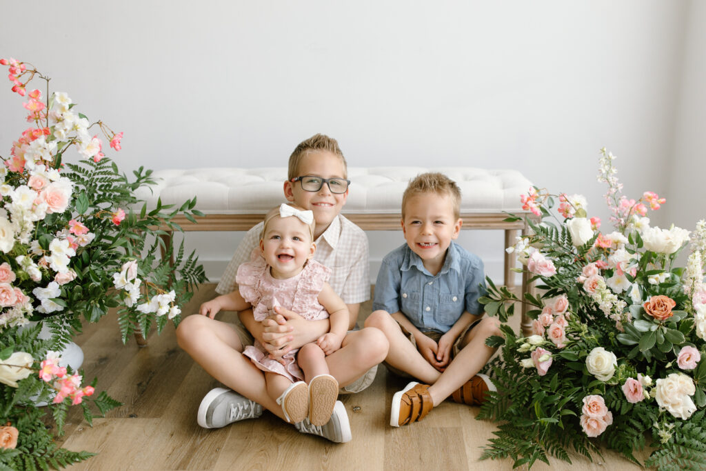 three kids sitting on the ground during Mother's Day Mini Sessions at Aspiring Eden Studio in Indianapolis