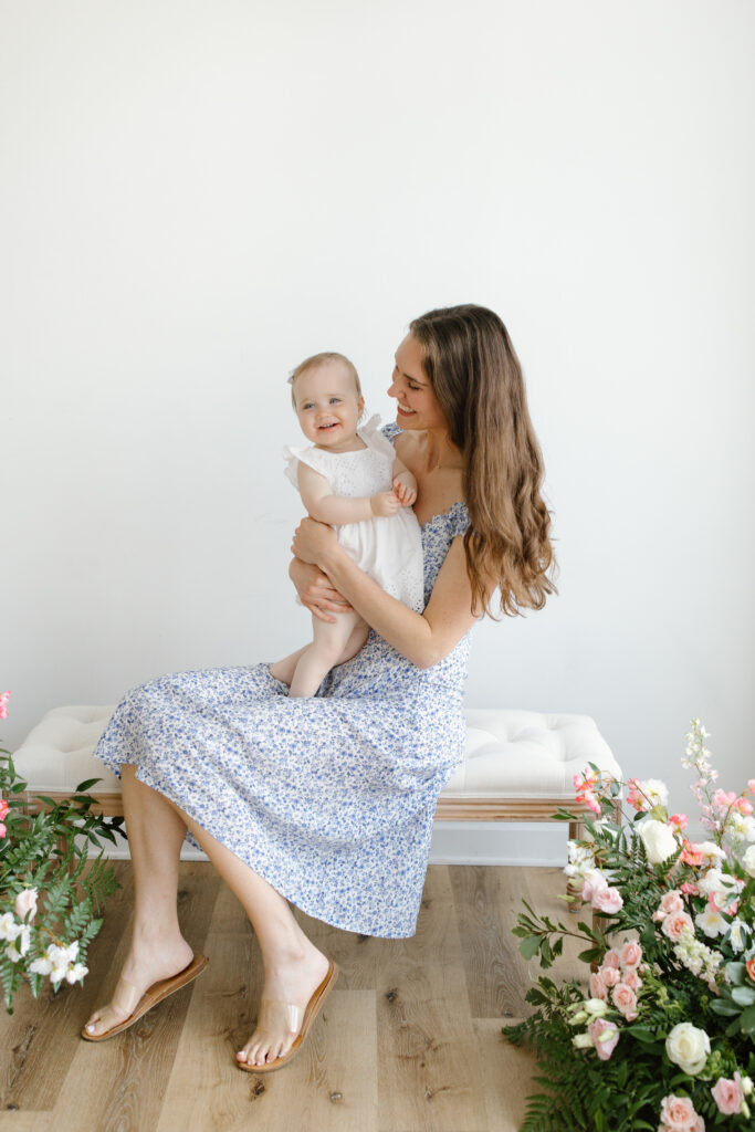 Mom holding daughter and sitting on bench during Mother's Day Mini Sessions at Aspiring Eden Studio in Indianapolis