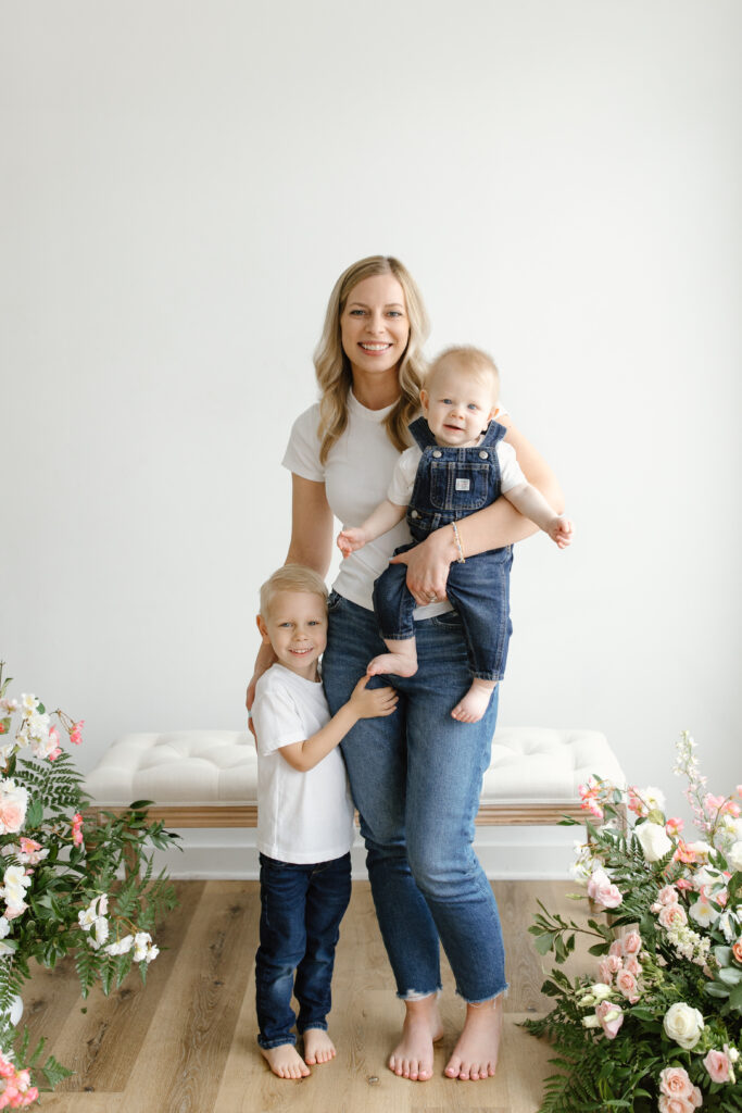 Mom holding sons and smiling to camera during Mother's Day Mini Sessions at Aspiring Eden Studio in Indianapolis