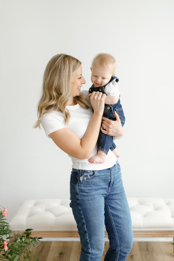 Mom hugging and smiling towards son during Mother's Day Mini Sessions at Aspiring Eden Studio in Indianapolis