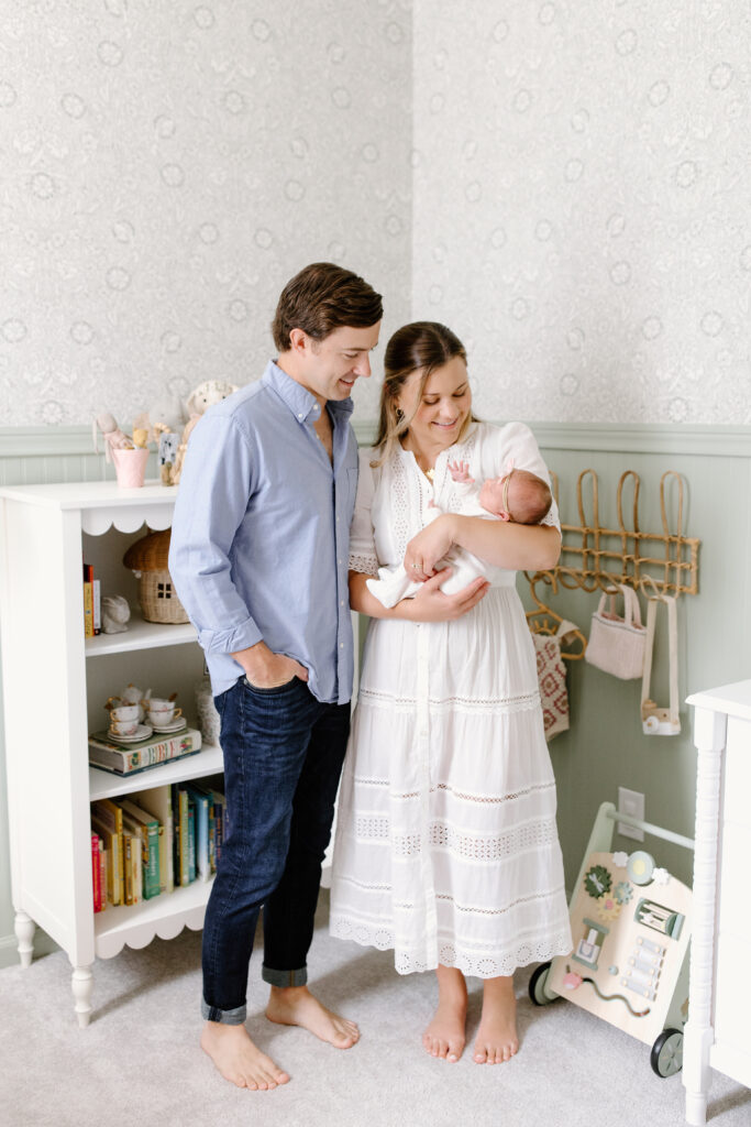 parents standing and holding baby during newborn photos in Fishers, IN