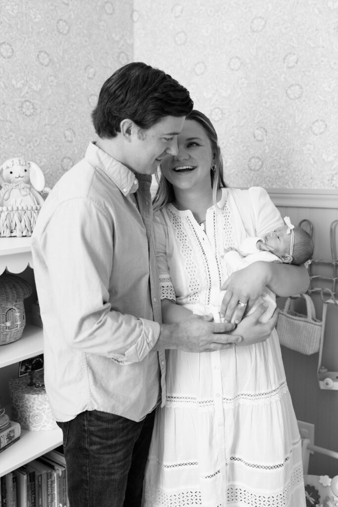 black and white image of parents holding baby during newborn photos in Fishers, IN