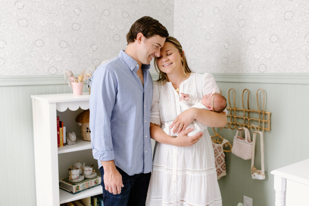 parents snuggling in and holding newborn during newborn photos in Fishers, IN
