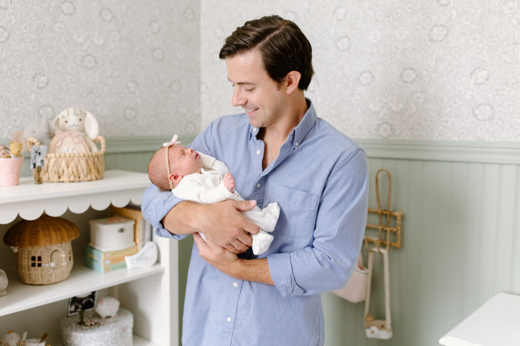 dad holding little girl during newborn photos in Fishers, IN