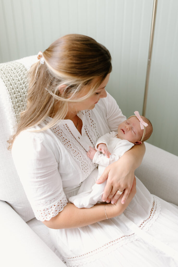 mom looking down towards little girl during newborn photos in Fishers, IN