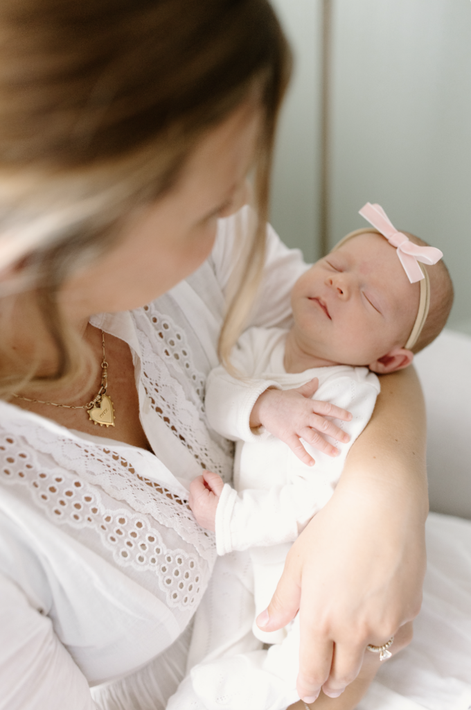 close up of baby girl being held by mom during newborn photos in Fishers, IN