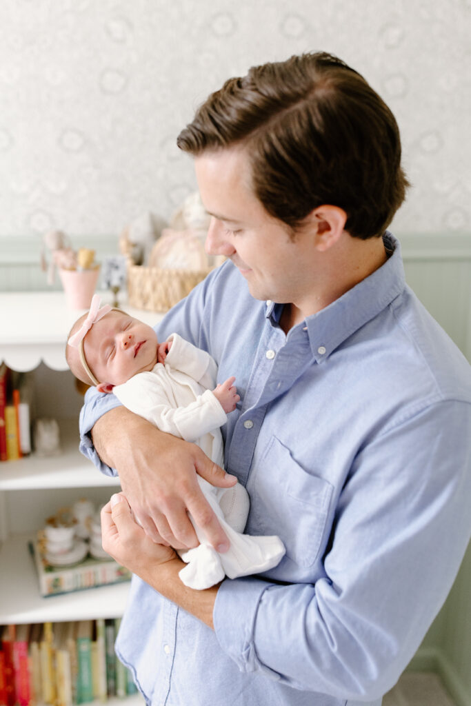 close up of baby asleep in dad's arms during newborn photos in Fishers, IN