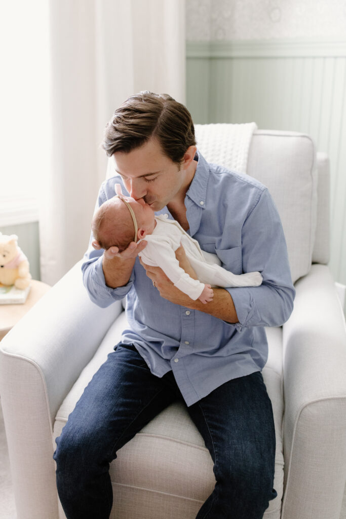 dad kissing newborn girl during newborn photos in Fishers, IN