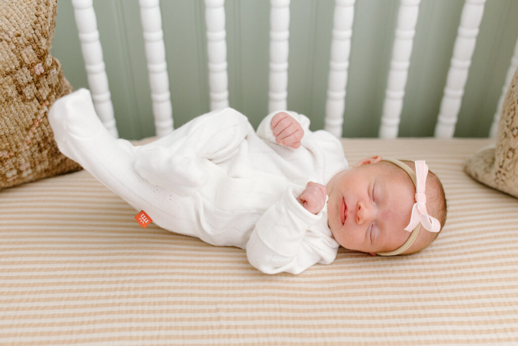little girl kicking during newborn photos in Fishers, IN