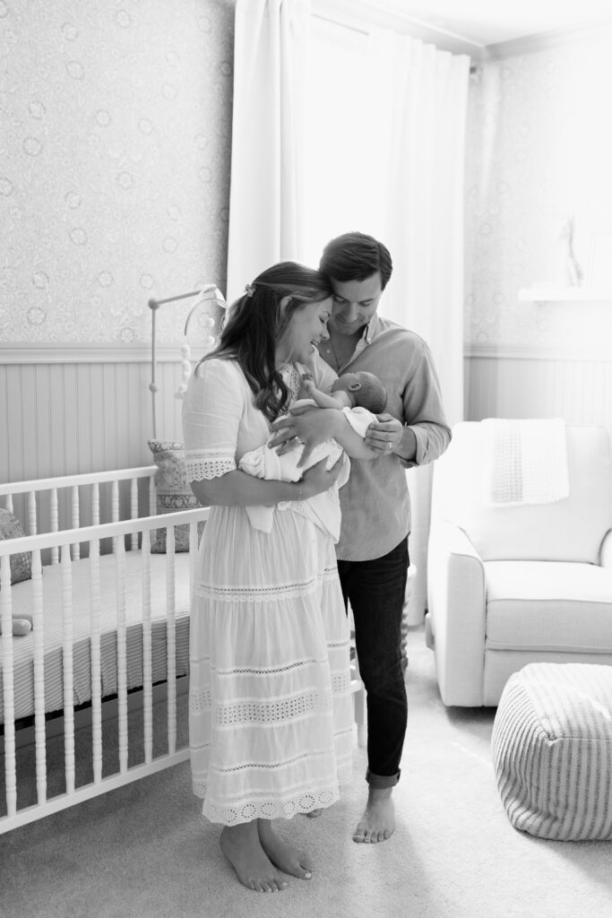 black and white of parents holding baby during newborn photos in Fishers, IN