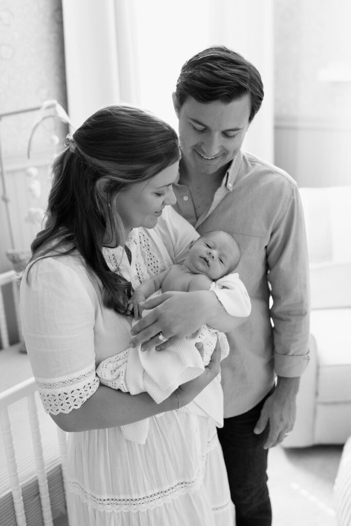 black and white of parents holding baby during newborn photos in Fishers, IN