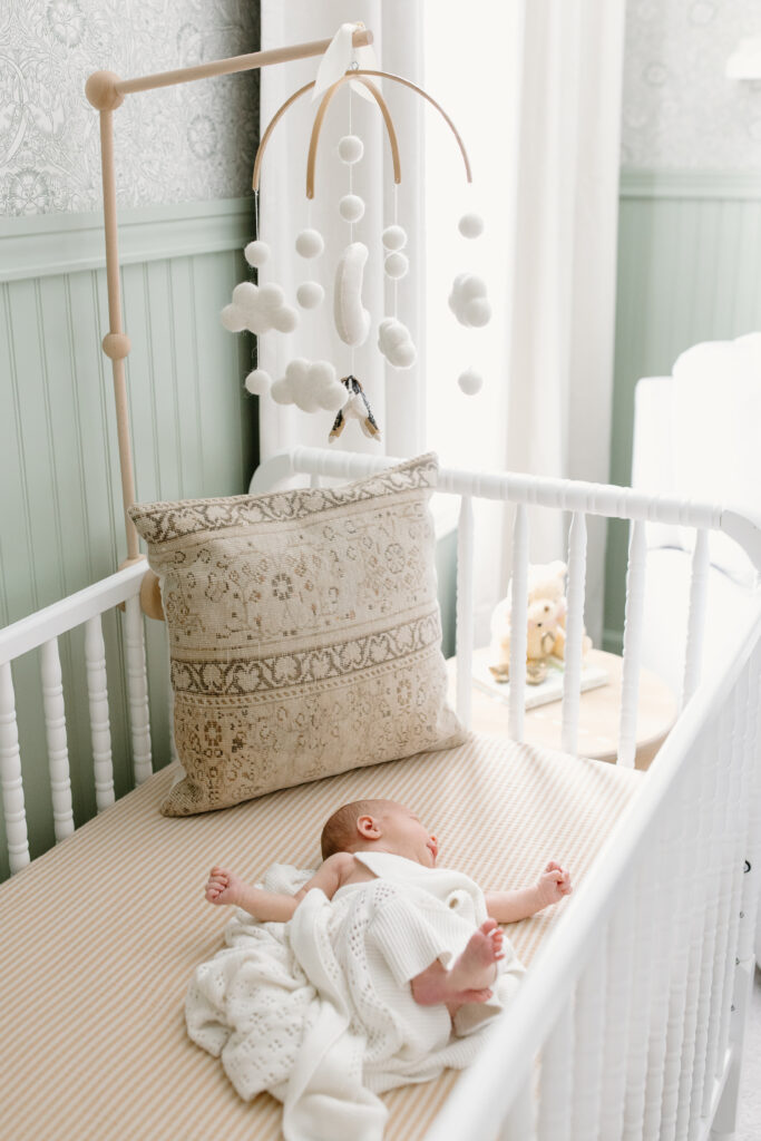 baby lying in crib during newborn photos in Fishers, IN