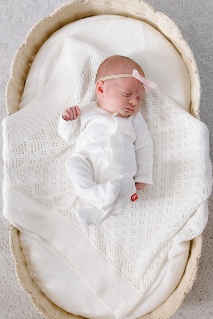 baby laying in bsekt during newborn photos in Fishers, IN