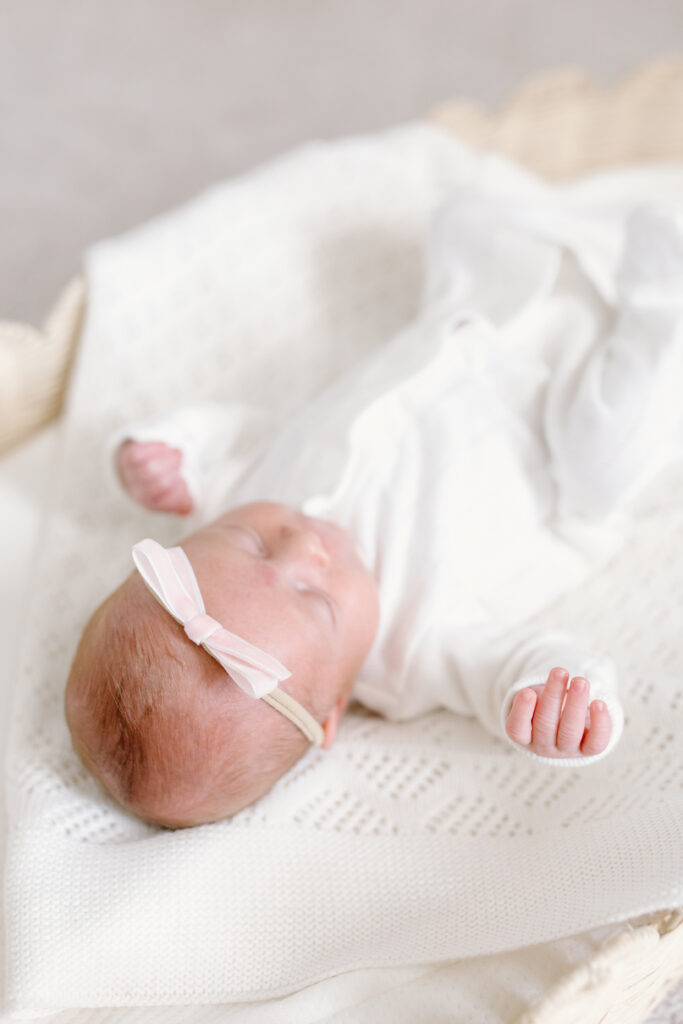 detail photo of baby's hair, hand and bow during newborn photos in Fishers, IN