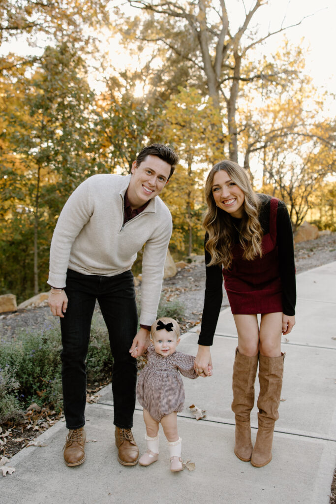 Mom and dad walking with baby during fall mini session in Carmel, IN with capturing simplicity photography