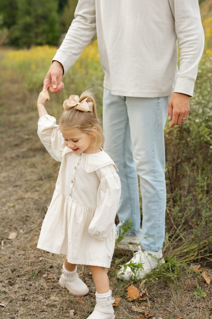 Dad dancing with daughter during fall family photos at West Park in with Capturing Simplicity Photography