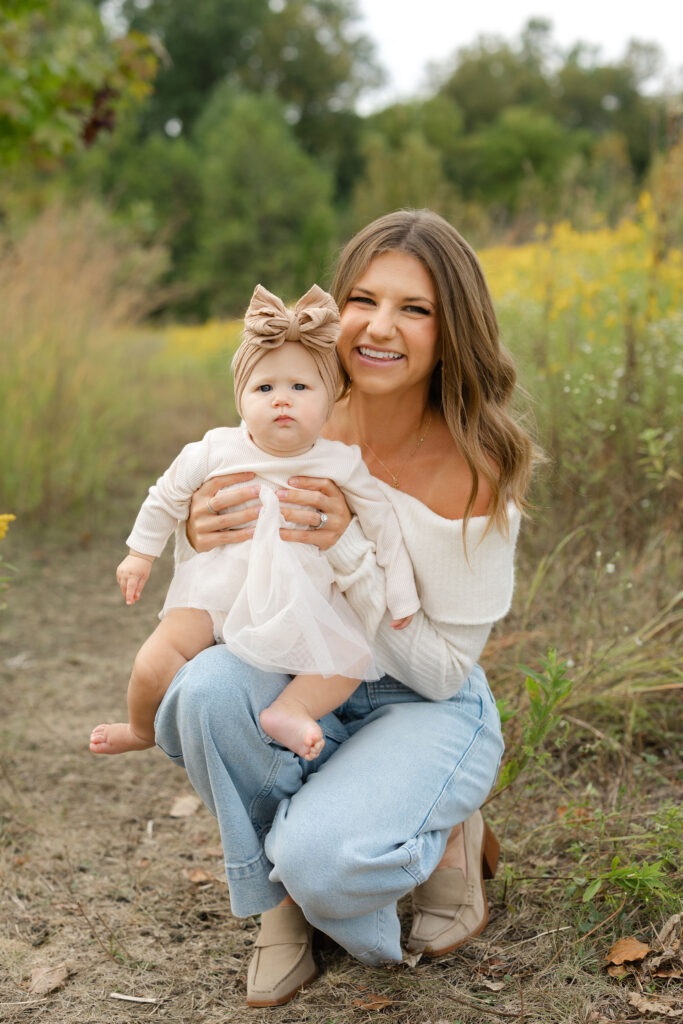 Mom holding daughter on her lap during fall family photos at West Park in with Capturing Simplicity Photography