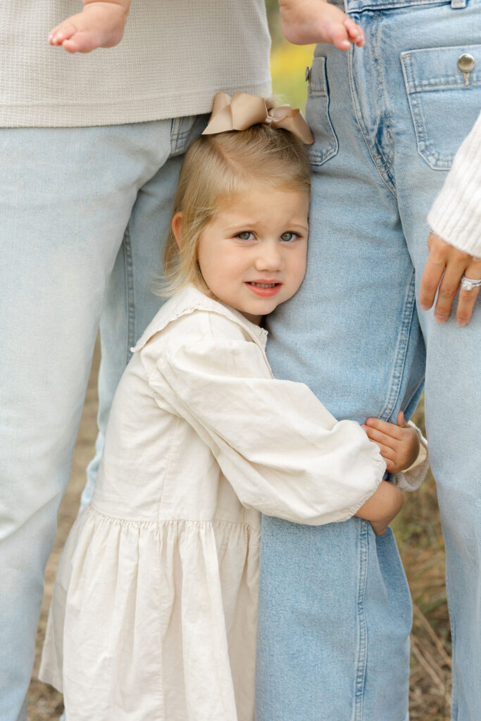 Daughter hugging mom during fall family photos at West Park in with Capturing Simplicity Photography