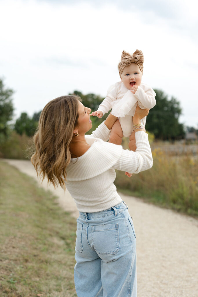 Mom playing airplane with daughter during fall family photos at West Park in with Capturing Simplicity Photography