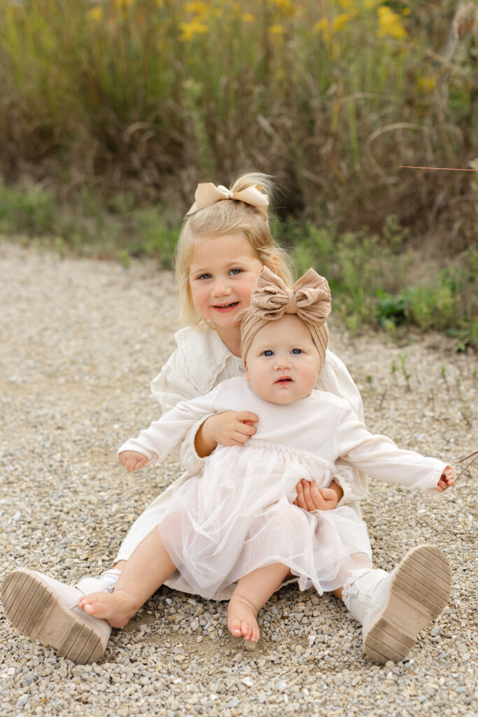 Sisters smiling during fall family photos at West Park in with Capturing Simplicity Photography