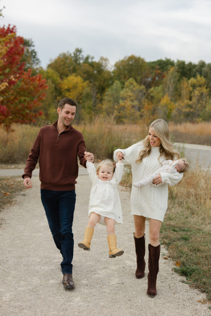Family swinging little girl during Fall Mini Sessions at West Park with Capturing Simplicity Photography