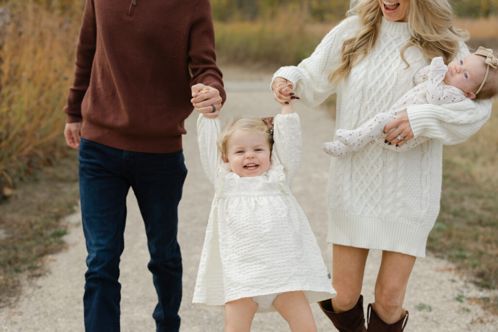 Little girl laughing and swinging during Fall Mini Sessions at West Park with Capturing Simplicity Photography