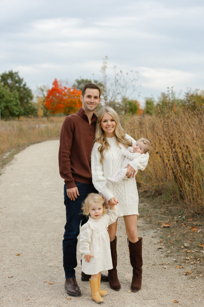 Family smiling on fall path during Fall Mini Sessions at West Park with Capturing Simplicity Photography